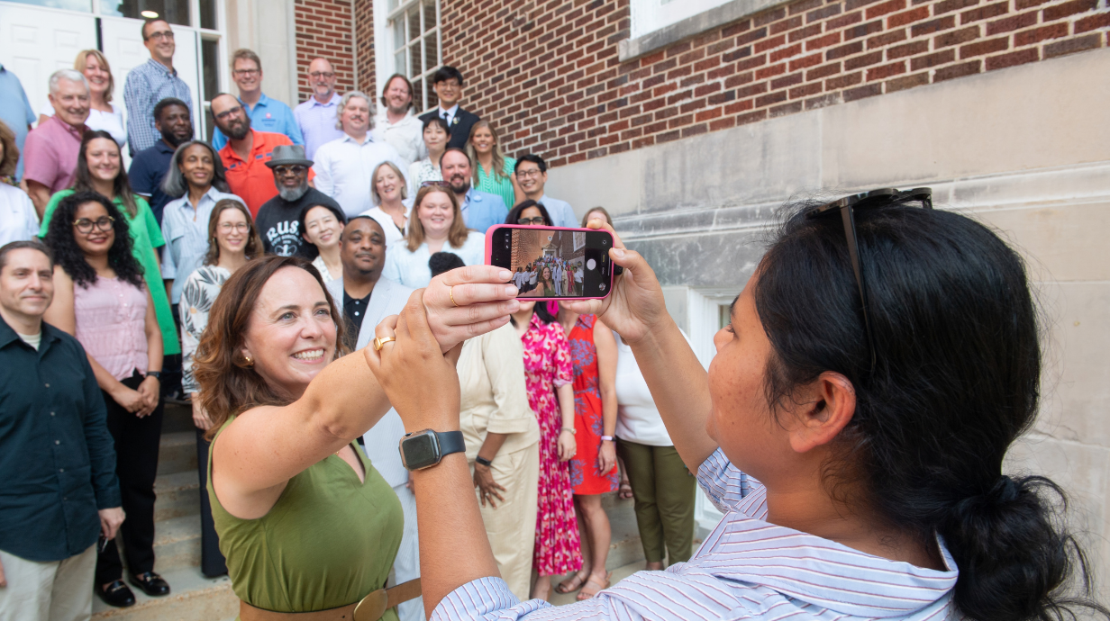 Faculty members take a selfie on steps of building