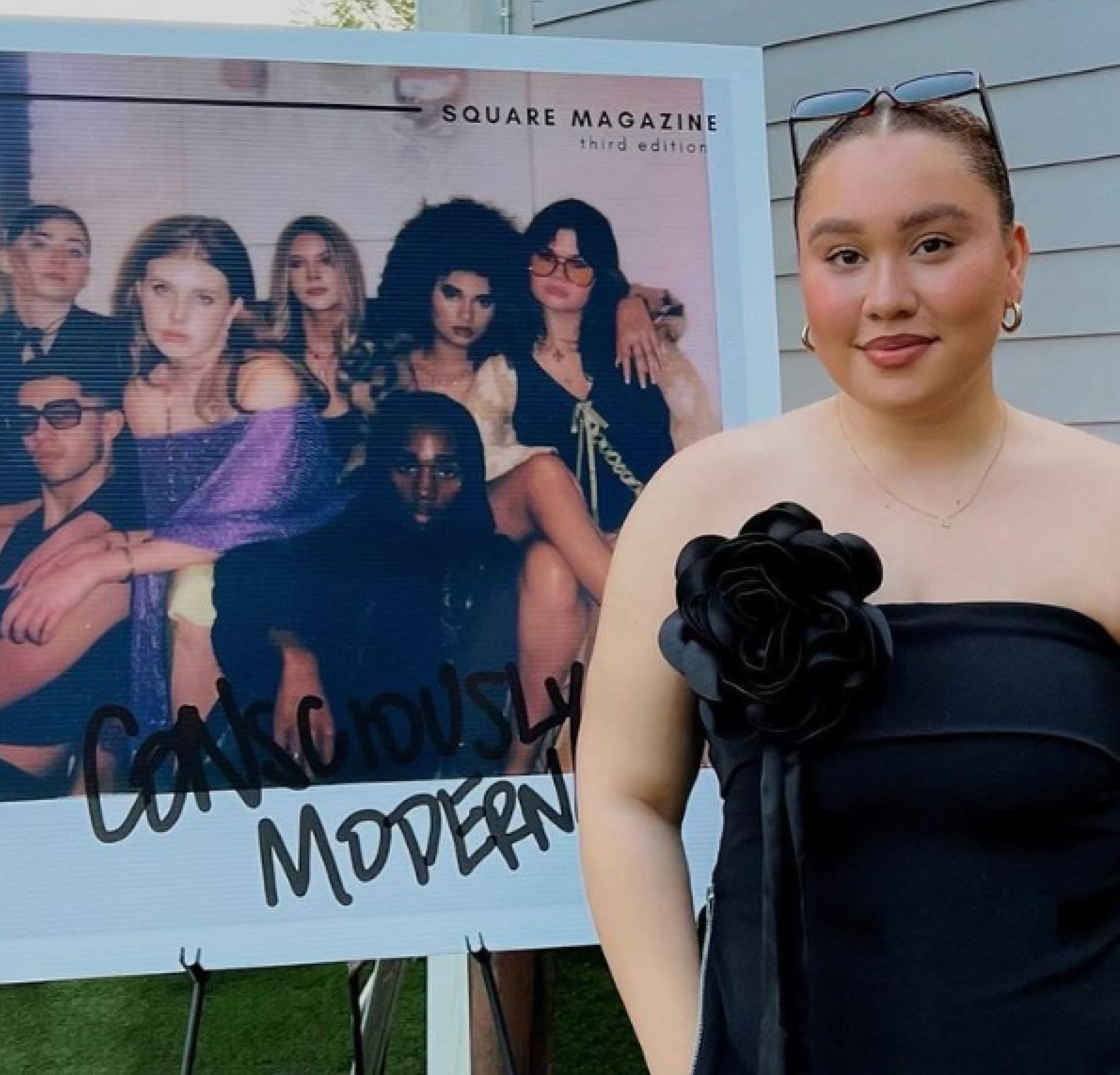 Student poses for a photo in front of a Square Magazine sign.