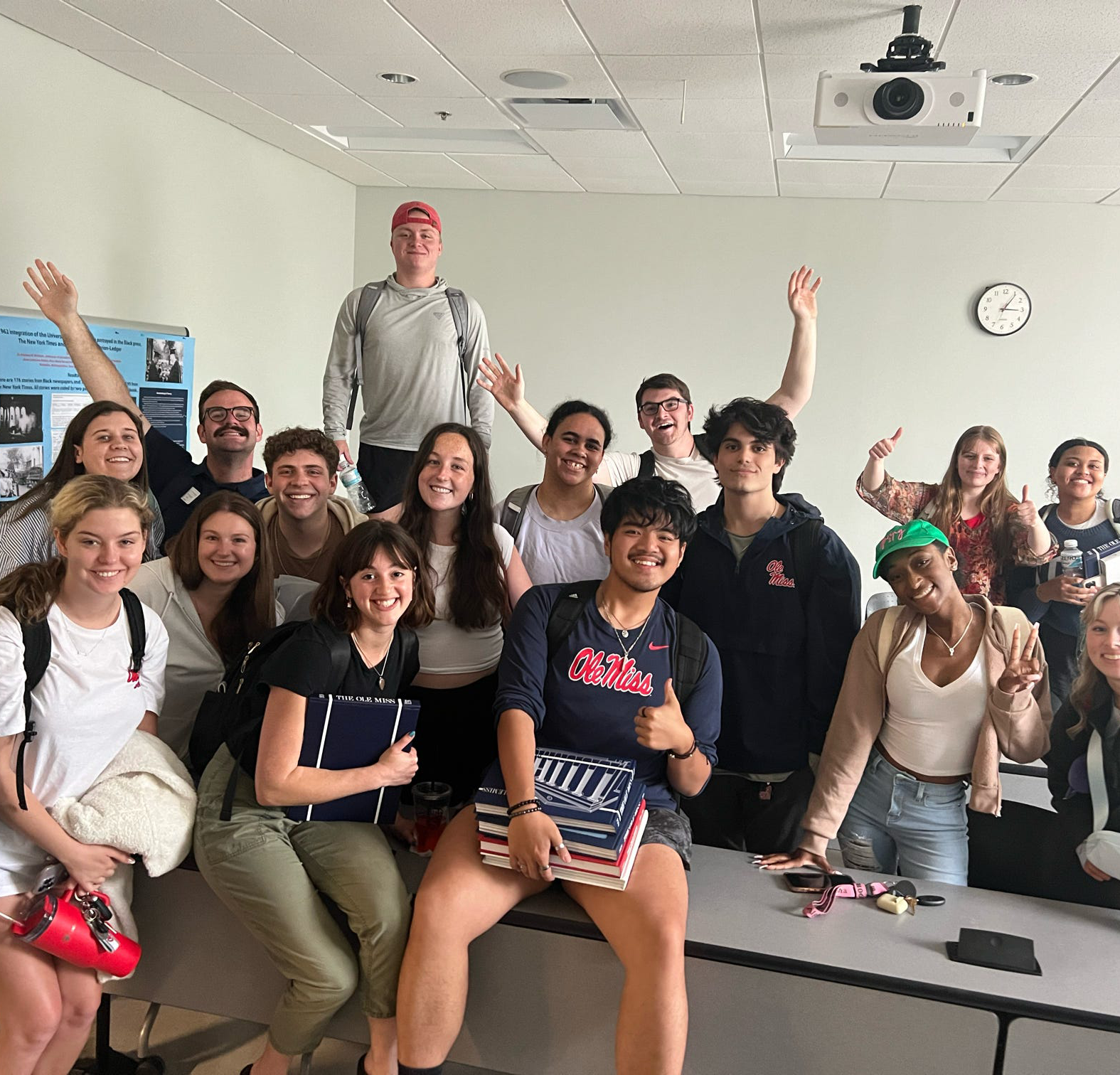 A group of students pose for a photo in a classroom.