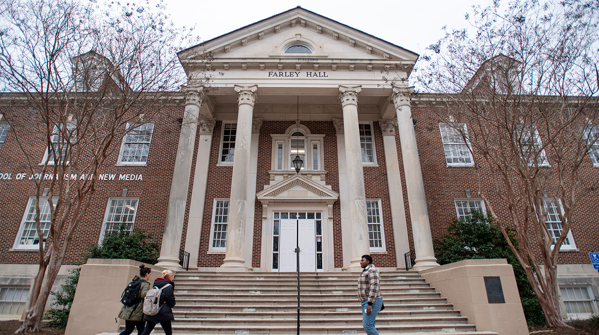 Students and faculty walk in front of Farley Hall on the University of Mississippi campus.