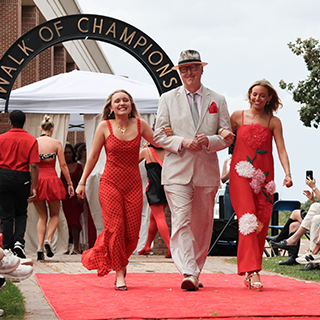Students and faculty member walk down the Walk of Champions.