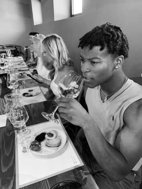 Ben Johnson and other students have a meal together in Italy. 
