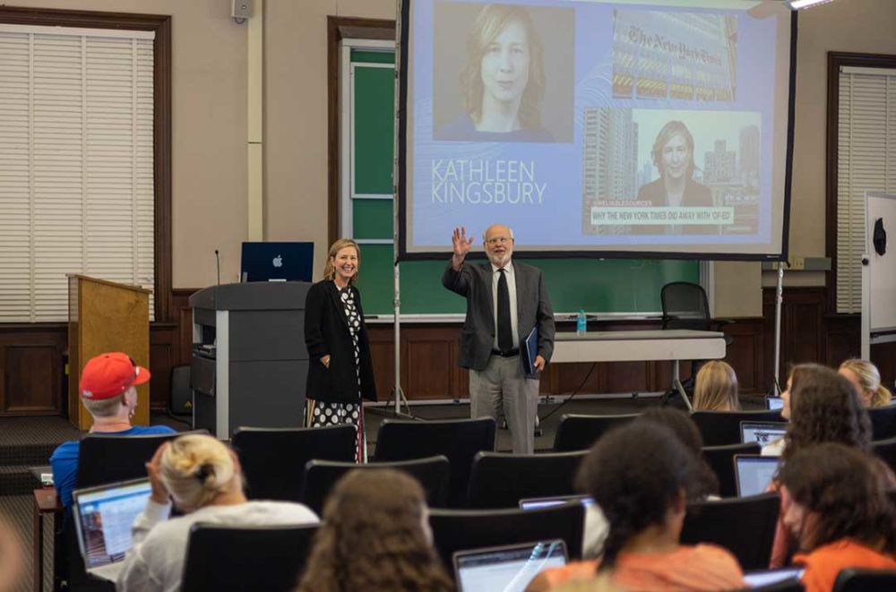 Kathleen Kingsbury, of The New York Times, stands with Professor Charlie Mitchell at the front of his class. 