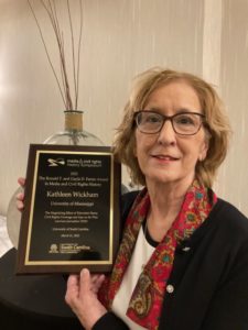 Photo of Kathleen Wickham holding a plaque